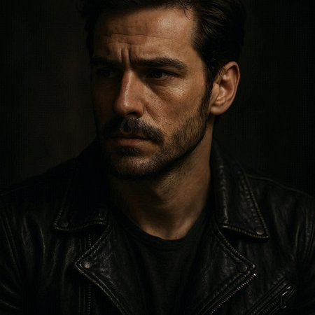 Portrait of a handsome man in a leather jacket on a dark background