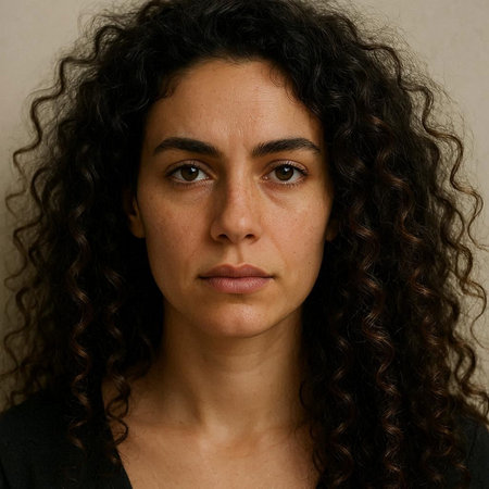 Portrait of a woman with curly hair looking at the camera.