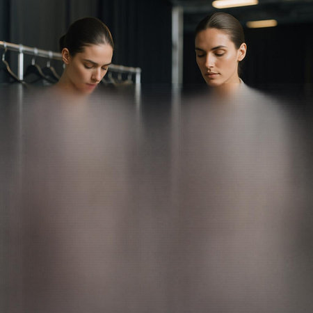 beautiful young woman looking at reflection in mirror in modern dressing room