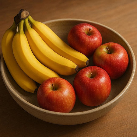 Bowl of fresh bananas and apples on wooden table, closeup