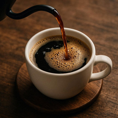 Coffee pouring into a cup of coffee on a wooden table