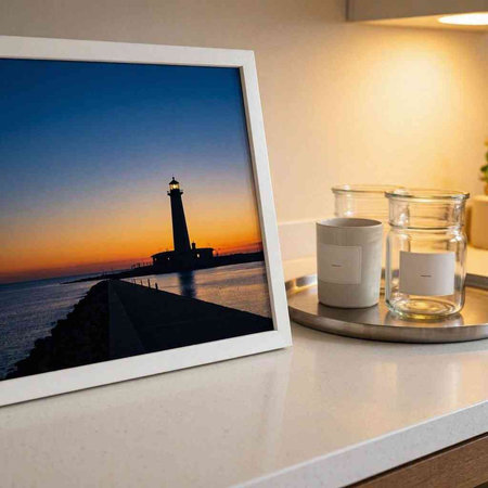 Lighthouse and glass of water on a white table in the morning