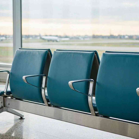 Waiting area in the airport terminal. Airplane in the background.