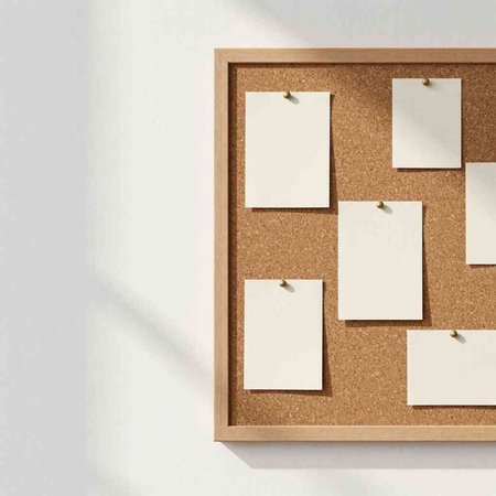 Cork board with blank sheets of paper pinned to the wall.