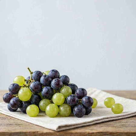 Grapes on a linen napkin on a wooden background.