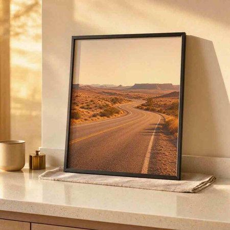 A picture of a road through the desert in a photo frame.