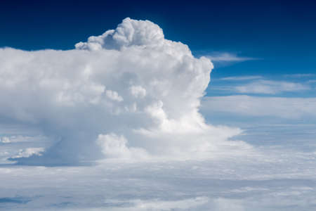 Bright blue sky above puffy white clouds.の写真素材
