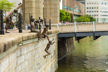 Bronze statues of kids jumping into river in singporeのeditorial素材