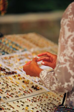 Woman trying on a ring at market stand selling jewelryの写真素材