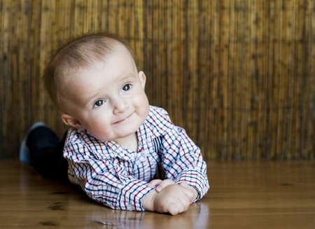 The small cheerful kid lie on a floor.の写真素材