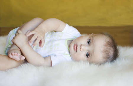 The little boy lies on a fur rugの写真素材