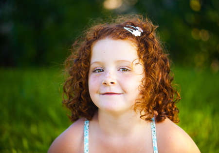 Redheaded beautiful girl on a background of nature