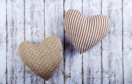 Two hearts made of cloth on a wooden backgroundの写真素材