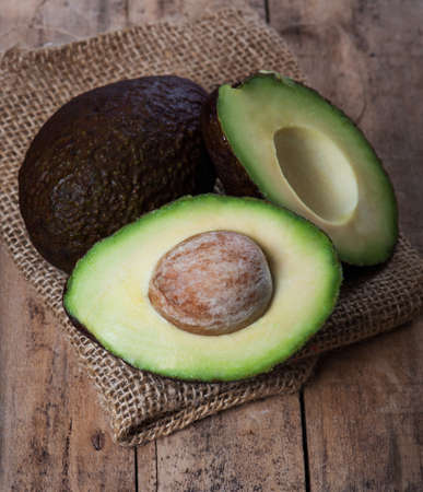 Ripe avocado on a wooden board in the studio