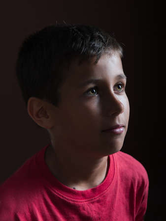 young cute boy on a dark backgroundの写真素材