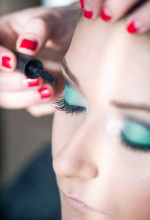 Professional make-up artist prepares a model for a photo shoot