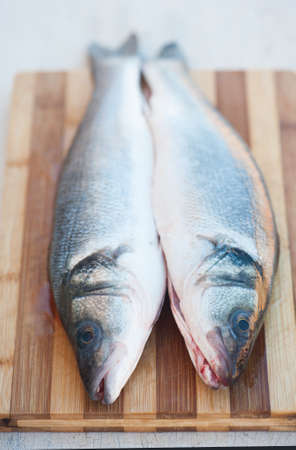 Fresh fish on a cutting board prepared for cookingの写真素材