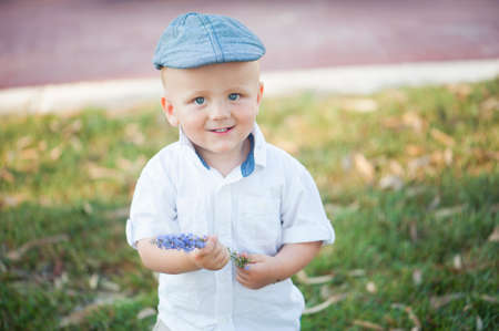 Cute little boy in a cap on a background of natureの写真素材