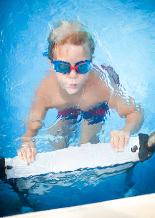 Boy swimming in the pool and it is under waterの写真素材