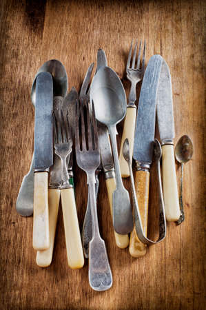old vintage cutlery on a wooden tableの写真素材