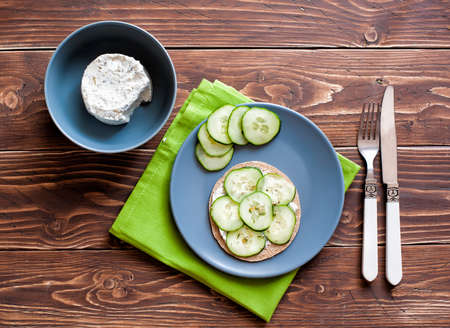 Sandwich with cheese and fresh cucumbers on the wooden backgroundの写真素材