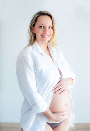 Cute pregnant girl on a white backgroundの写真素材