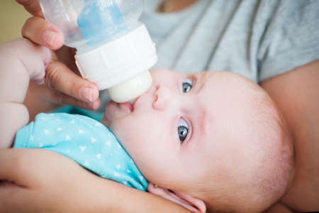 Little Baby drinking milk from a bottleの写真素材