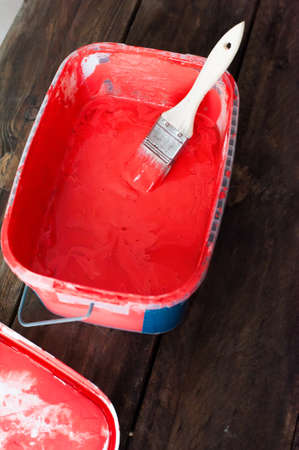 Red paint in a bucket on a wooden backgroundの写真素材