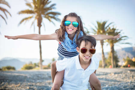 Cheerful cute boy and girl playing outdoorsの写真素材