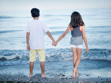 Young boy and girl looking at seaの写真素材