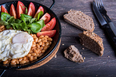 Breakfast with beans, tomatoes, eggs and bread.の写真素材