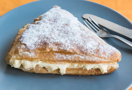 Folded bun triangle with cream on a gray plate