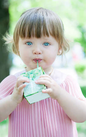little lovely girl drinking juiceの写真素材