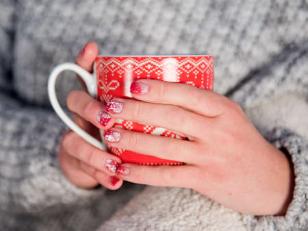 New Years mug in female hands with beautiful New Year manicuresの写真素材
