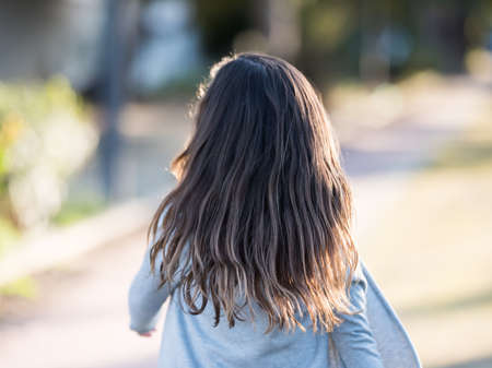 Little girl running and hair flapping in the windの写真素材