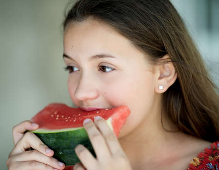 Young beautiful girl is eating watermelon.の写真素材