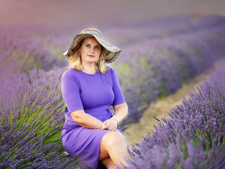 Beautiful young woman in a beautiful hat in the fields of lavenderの写真素材