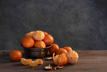 Tangerines close-up in a cup on a wooden background