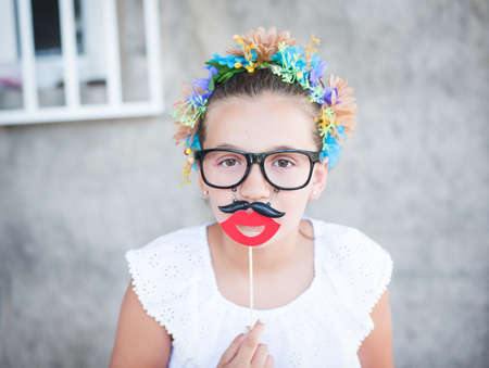Beautiful girl with Santa beard and mustache prop or mask.の写真素材