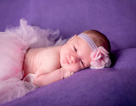 Cute newborn girl with a bandage on her headの写真素材