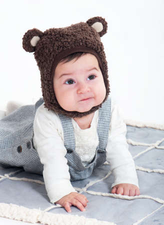 kid in a cap of a small bear on a white backgroundの写真素材