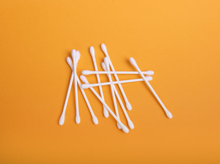 White cotton swabs on an orange backgroundの写真素材