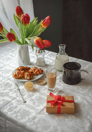 Breakfast on the table with tulips by the windowの写真素材