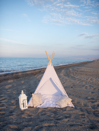 decorative tent with pillows on the beach at sunset.の写真素材