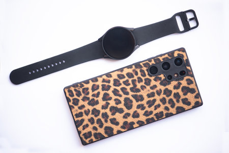 smart phone and smart watch on cream color background.