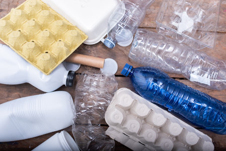 Various types of plastic waste including bottles, containers, and packaging materials scattered on a...