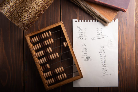 Vintage wooden abacus with accounting sheet on desk for financial history, math education or...