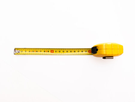 Yellow tape measure lying horizontally on white background for construction tool shop or DIY...