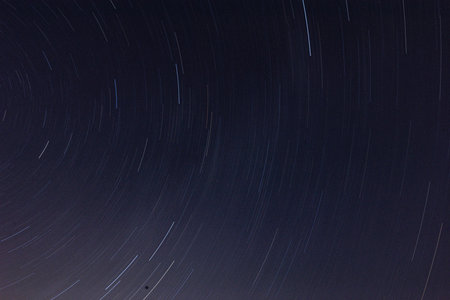 Star trails in the night sky. Long exposure photograph with grain.