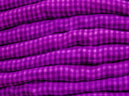 A pile of colorful clothes on top of each other with fabric details in pink and blackの写真素材